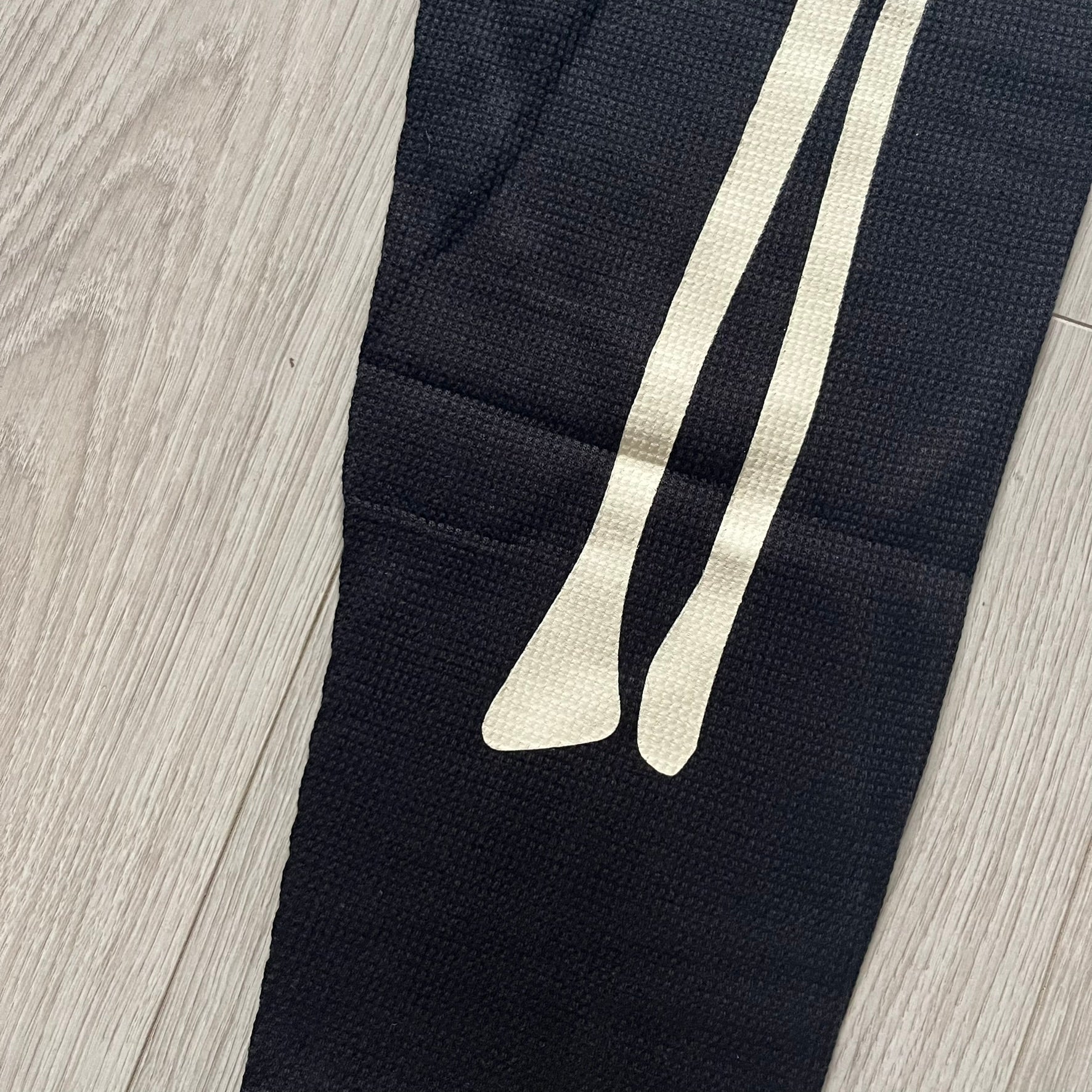  Supreme Hanes Bones Thermal Pant FW25 in black, crafted from 100% cotton. Features white skeletal bone prints running down both legs and a black elastic waistband with white Supreme branding throughout. Released October 23, 2025.