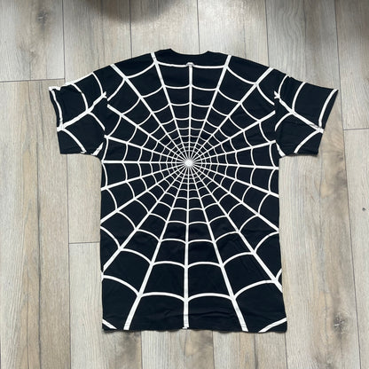 Supreme Hanes SS26 Spider-Man Black Tagless Tee is a black all-cotton crewneck T-shirt from the Spring/Summer 2026 collection, produced on a Hanes tagless blank. The shirt features an all-over white web print covering the front, back, and sleeves, with a small red Supreme stamp logo printed near the bottom corner.