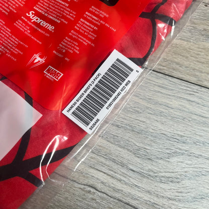 Supreme Hanes SS26 Spider-Man Red Boxer Briefs are made of cotton with a stretch fit. Features a red elastic waistband with white Supreme logo text and an all-over black web print. Classic Hanes base model a Spider-Man twist.