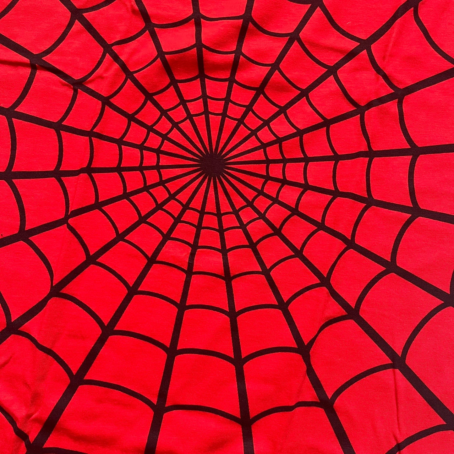 Supreme Hanes SS26 Spider-Man Red Tagless Tee is a red all-cotton crewneck T-shirt from the Spring/Summer 2026 collection, produced on a Hanes tagless blank. The shirt features an all-over black web print covering the front, back, and sleeves, with a small red Supreme stamp logo printed near the bottom corner.