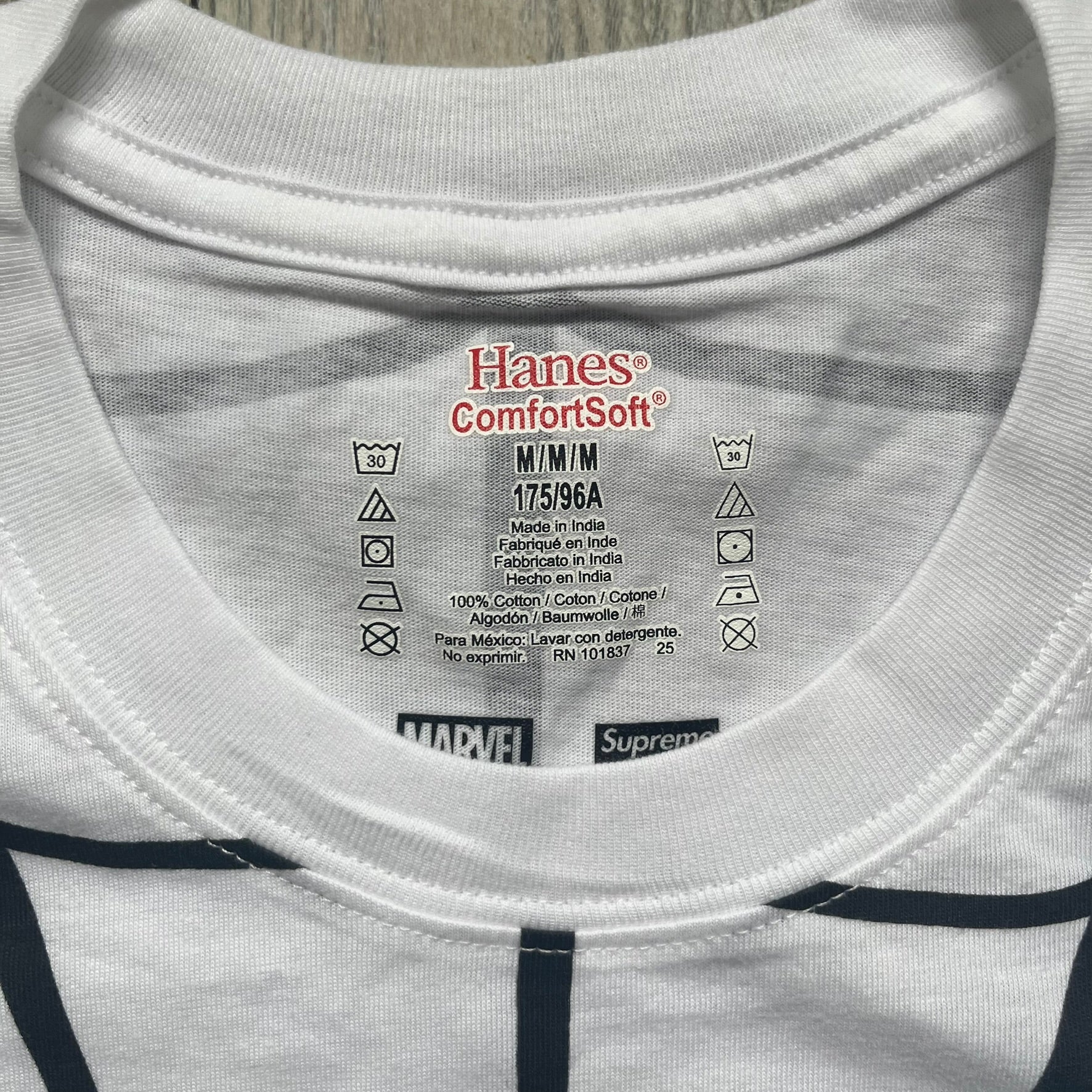 Supreme Hanes SS26 Spider-Man White Tagless Tee is a white all-cotton crewneck T-shirt from the Spring/Summer 2026 collection, produced on a Hanes tagless blank. The shirt features an all-over black web print covering the front, back, and sleeves, with a small red Supreme stamp logo printed near the bottom corner.
