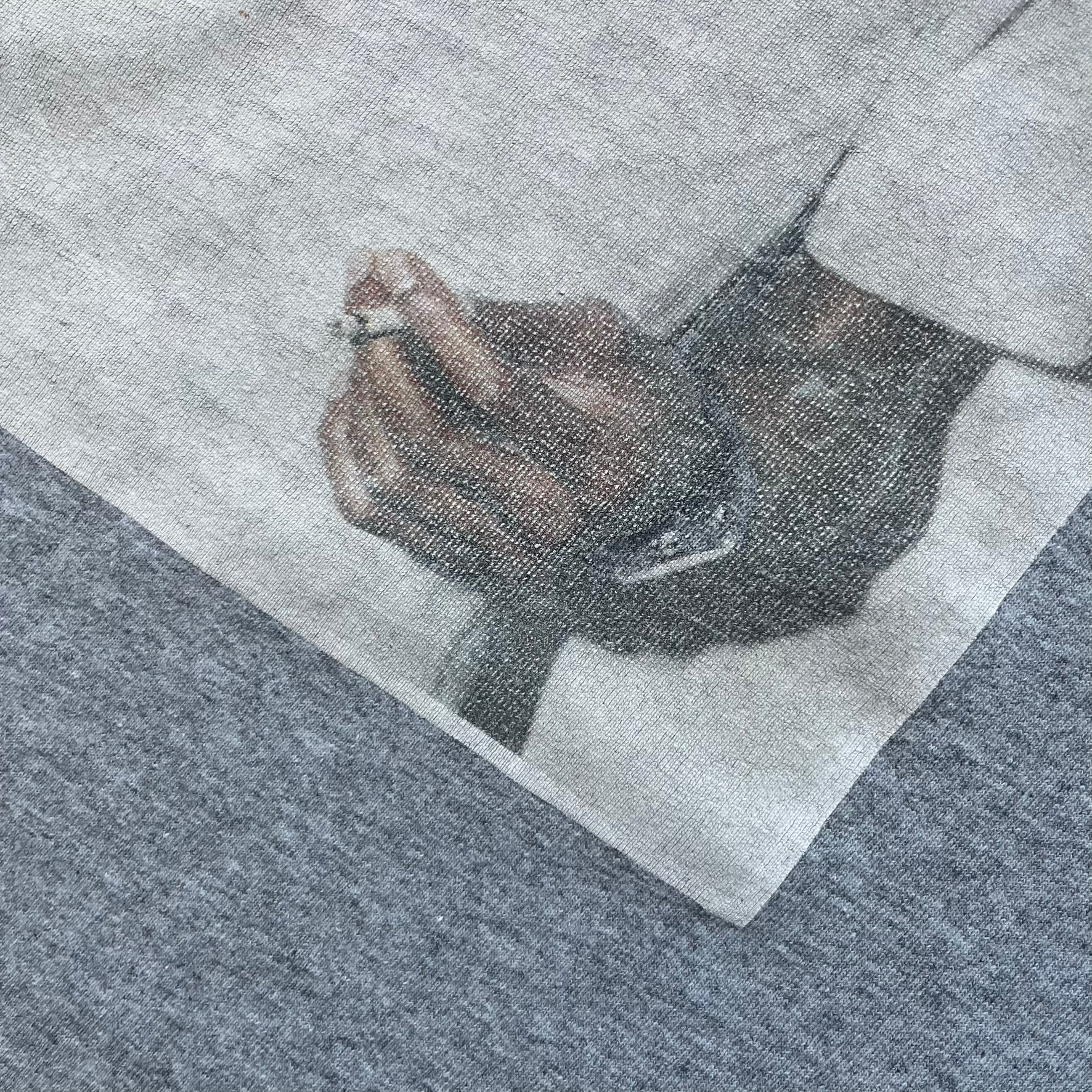 Supreme NBA Youngboy FW23 Gray Tee is a gray crew-neck T-shirt made in the USA from 100% cotton. The front features a multicolor graphic print of NBA Youngboy wearing the Supreme Box Logo tee. The shirt has short sleeves and a regular fit.