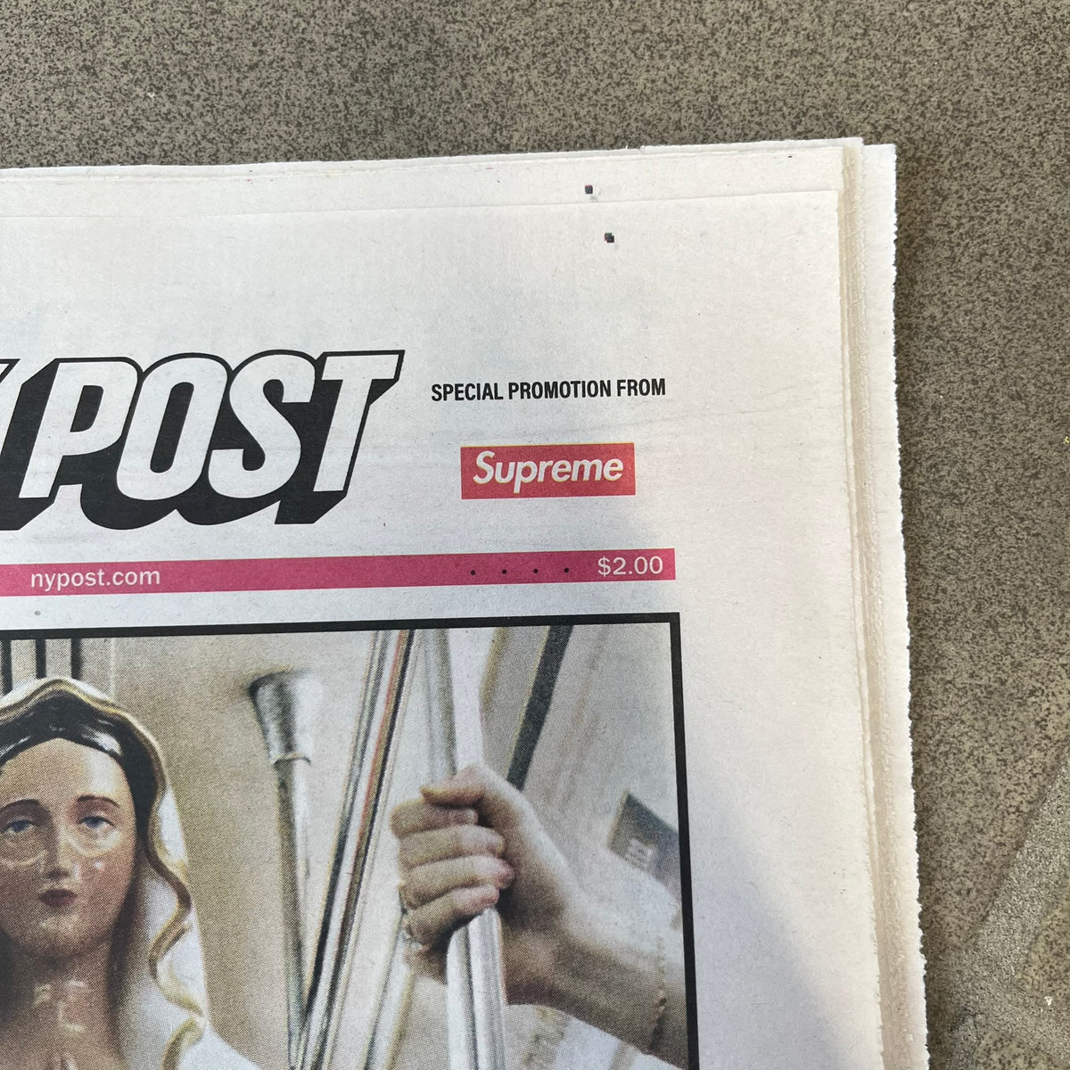 Supreme New York Post Newspaper “Late City Final Edition” from Fall/Winter 2026, released on August 17th, 2026. Features the features a religious statue with iconic Supreme box logo printed on it. On the back there's a "Deliver US From Evil". Includes the full original newspaper, with only the cover designed by Supreme.