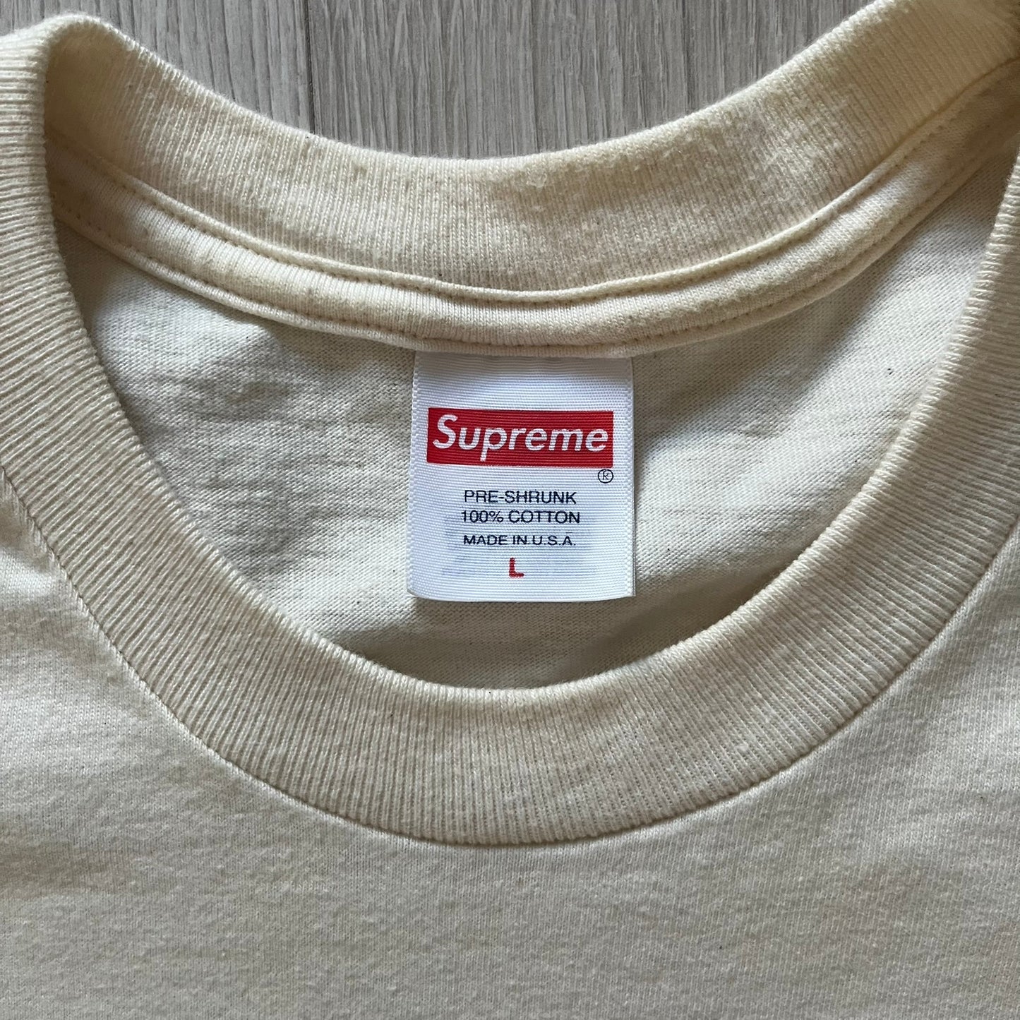 Natural Supreme tee from the FW23 season showcasing the “Payment” design. The front graphic depicts a pile of GBP banknotes with a large red graffiti-style Supreme tag layered across. A clean and minimalistic yet striking piece from the collection.