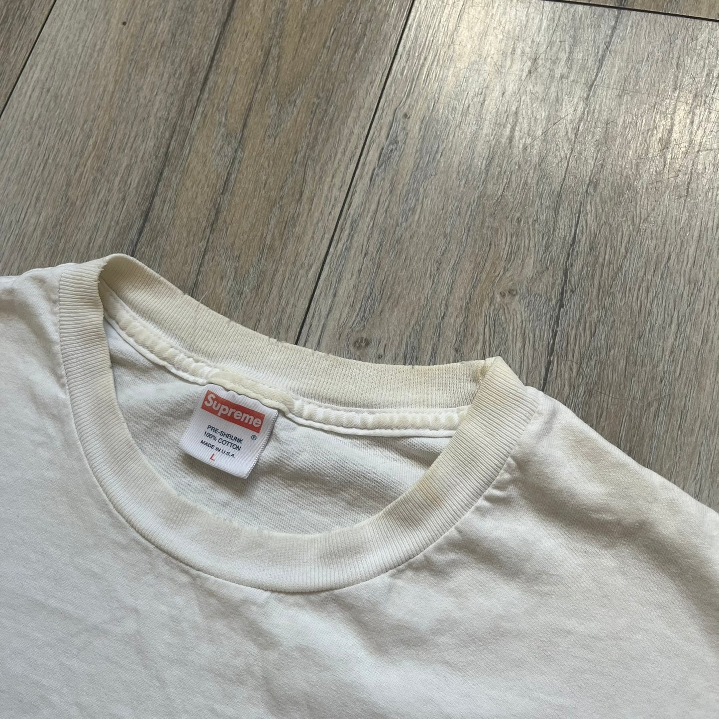 Supreme SS05 STAX Records White Gun Tee is a white short-sleeve T-shirt from the Spring/Summer 2005 collection. The front features a modified Stax Records-inspired logo with “Supreme” in red and a hand holding a gun graphic. This piece is super rare.