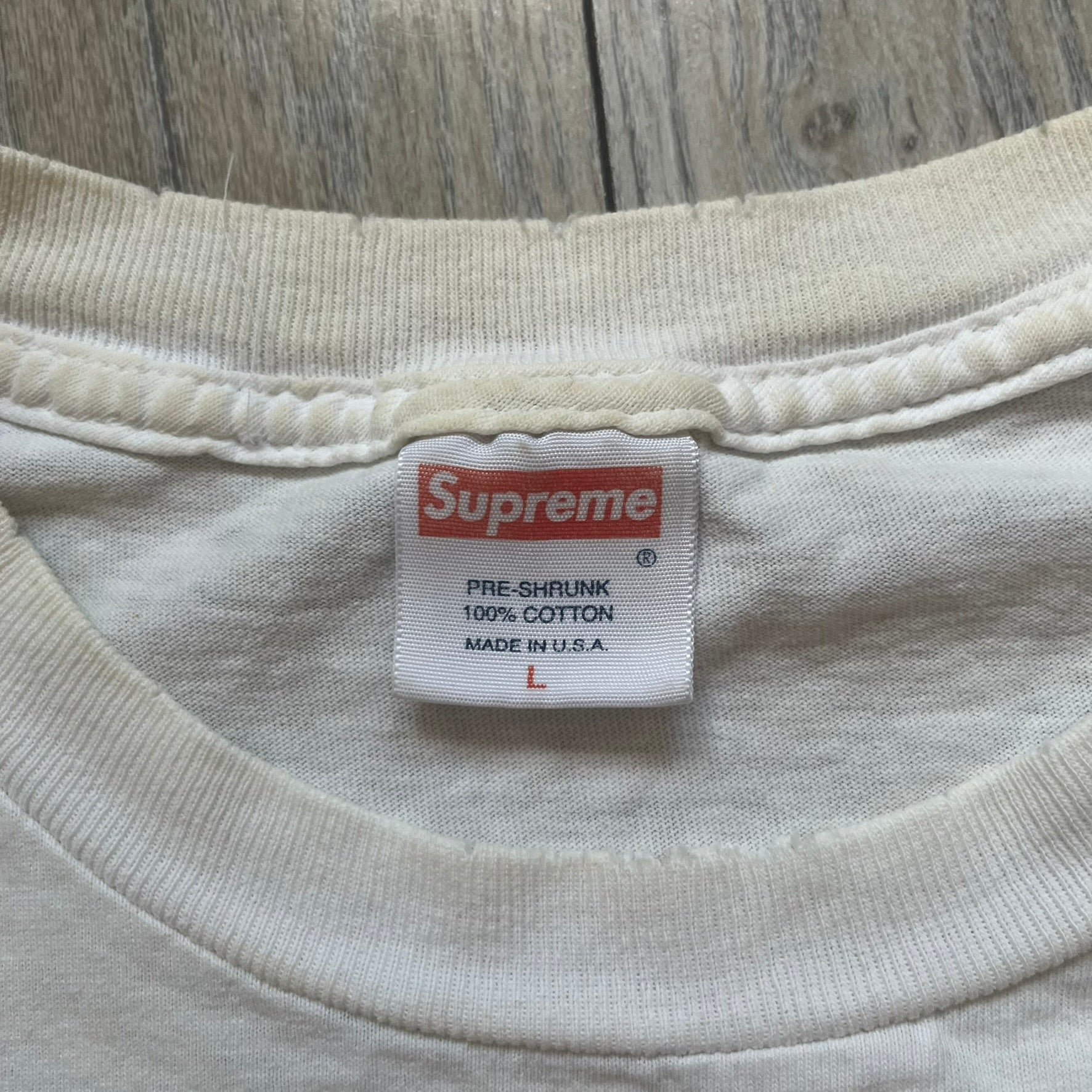 Supreme SS05 STAX Records White Gun Tee is a white short-sleeve T-shirt from the Spring/Summer 2005 collection. The front features a modified Stax Records-inspired logo with “Supreme” in red and a hand holding a gun graphic. This piece is super rare.