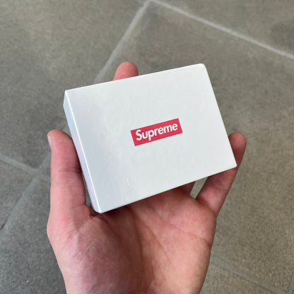 Supreme SS18 Hair Bobbles (Set of 2) features clear acrylic dice-shaped pieces with small red Supreme Box Logo details inside, attached to black elastic bands. The set includes two hair bobbles and comes in the original white Supreme box. Released on May 17, 2018.
