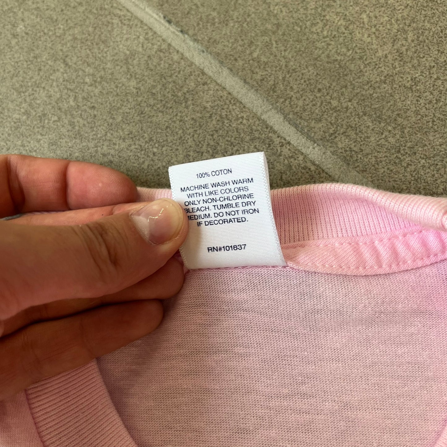 Supreme SS19 Greetings Pink Tee features a pink T-shirt with a front graphic designed as a greeting card showing the New York City skyline. The graphic includes the text “Greetings From Supreme” and depicts the original skyline with the Twin Towers. Released as part of Supreme’s Spring/Summer 2019 collection. Made in USA, 100% Cotton.
