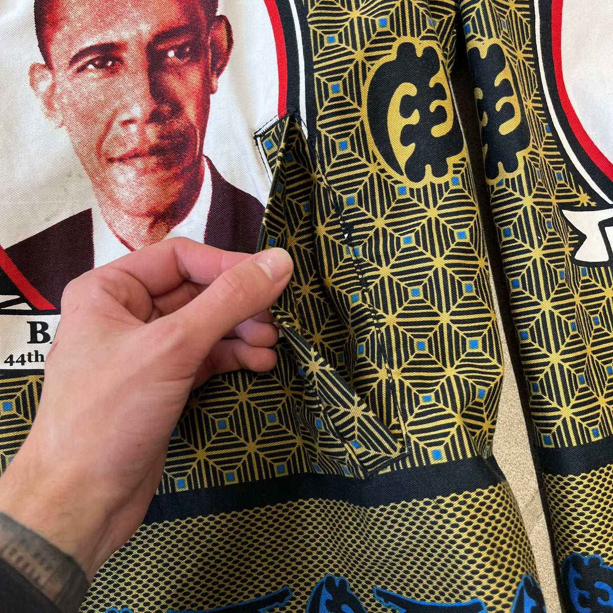 Supreme SS2017 Obama Green Anorak is a green/olive 100% cotton quarter-zip anorak with an all-over patchwork print incorporating Barack Obama’s face, the words “Barack Obama,” and scattered Supreme logos. The design pays homage to the “khanas,” vibrant patterned garments with political graphics made by local designers in Ghana to commemorate the former president’s 2009 visit. It has a drawstring hood and hem and lower front hand pockets.