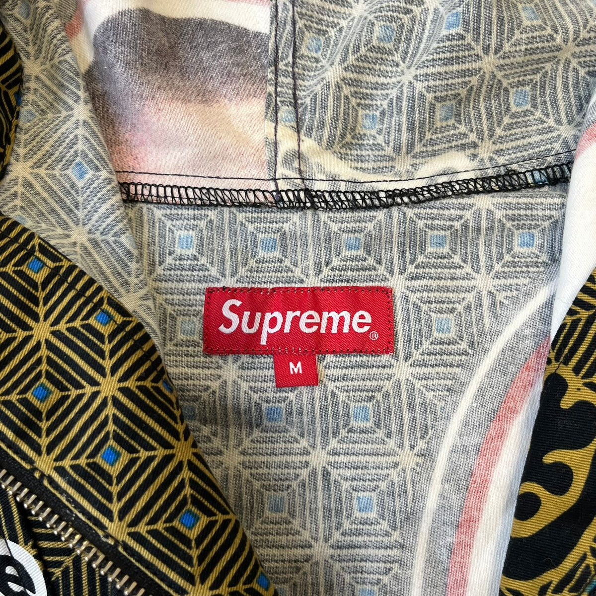 Supreme SS2017 Obama Green Anorak is a green/olive 100% cotton quarter-zip anorak with an all-over patchwork print incorporating Barack Obama’s face, the words “Barack Obama,” and scattered Supreme logos. The design pays homage to the “khanas,” vibrant patterned garments with political graphics made by local designers in Ghana to commemorate the former president’s 2009 visit. It has a drawstring hood and hem and lower front hand pockets.