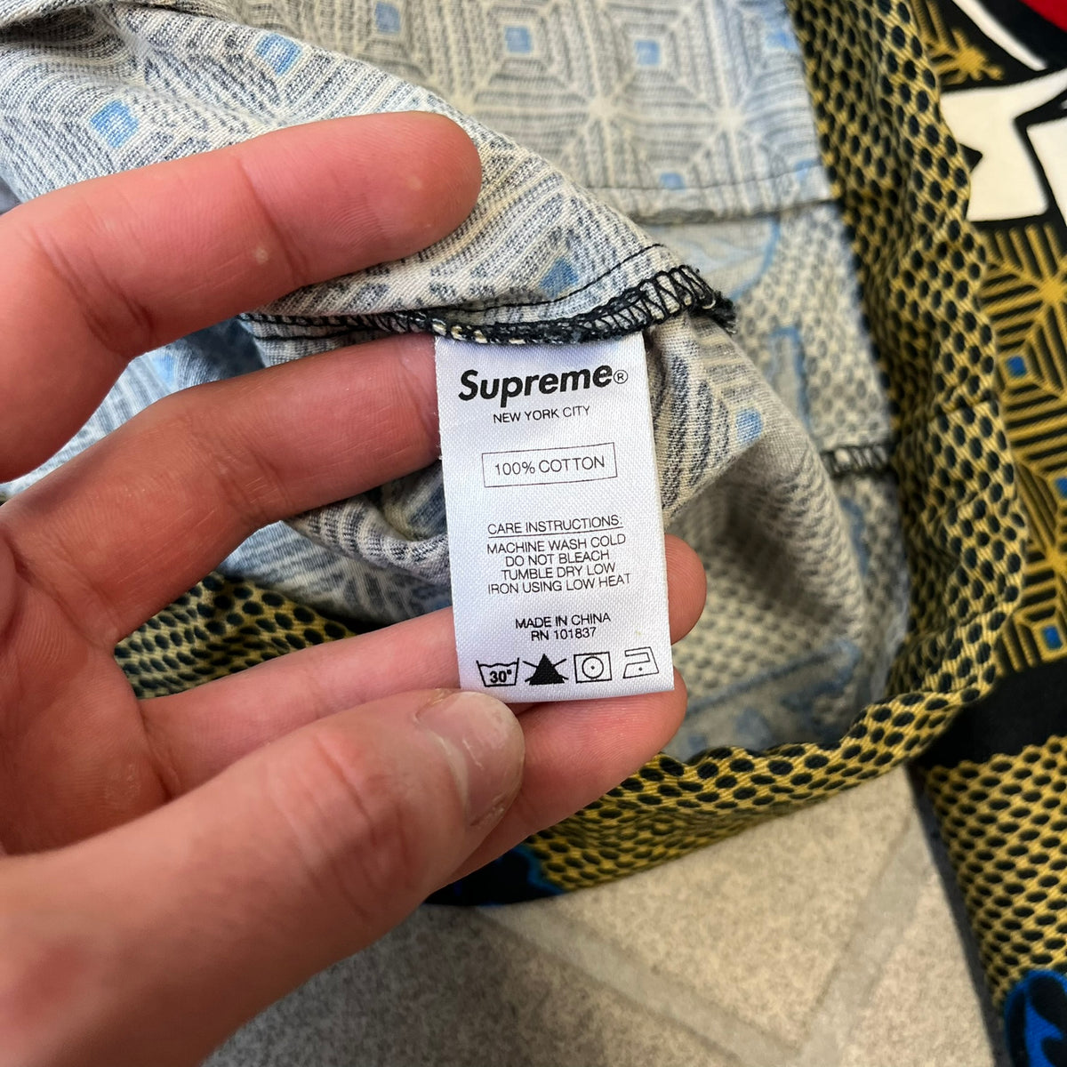 Supreme SS2017 Obama Green Anorak is a green/olive 100% cotton quarter-zip anorak with an all-over patchwork print incorporating Barack Obama’s face, the words “Barack Obama,” and scattered Supreme logos. The design pays homage to the “khanas,” vibrant patterned garments with political graphics made by local designers in Ghana to commemorate the former president’s 2009 visit. It has a drawstring hood and hem and lower front hand pockets.