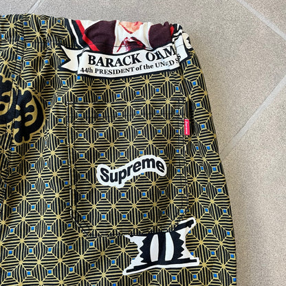 Supreme SS2017 Obama Green Pants are green/olive pants with the all-over patchwork print incorporating Barack Obama’s face, the words “Barack Obama,” and scattered Supreme logos. The design pays homage to the “khanas,” vibrant patterned garments with political graphics made by local designers in Ghana to commemorate the former president’s 2009 visit. They have two front pockets and one back pocket.