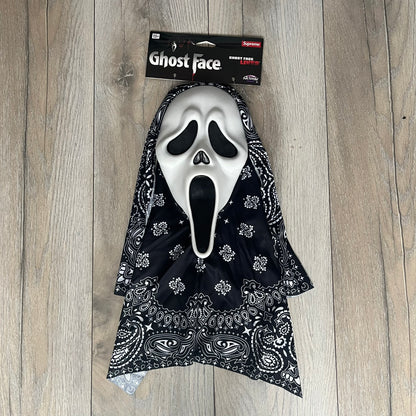 Supreme SS26 Ghostface Mask is a PVC face mask released on April 30, 2026, as part of the Spring/Summer 2026 collection. The mask features the classic white Ghostface design, combined with a black fabric hood element covered in white bandana-style patterns and integrated Supreme tags. Additional hanging strips on the sides enhance the hooded visual effect.