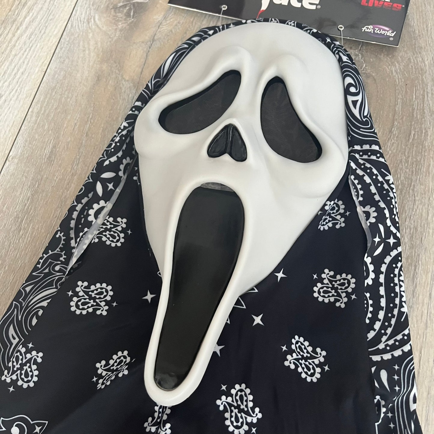 Supreme SS26 Ghostface Mask is a PVC face mask released on April 30, 2026, as part of the Spring/Summer 2026 collection. The mask features the classic white Ghostface design, combined with a black fabric hood element covered in white bandana-style patterns and integrated Supreme tags. Additional hanging strips on the sides enhance the hooded visual effect.