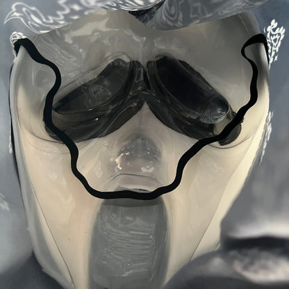 Supreme SS26 Ghostface Mask is a PVC face mask released on April 30, 2026, as part of the Spring/Summer 2026 collection. The mask features the classic white Ghostface design, combined with a black fabric hood element covered in white bandana-style patterns and integrated Supreme tags. Additional hanging strips on the sides enhance the hooded visual effect.
