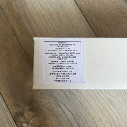 Supreme SS26 Mini Materials 1:12 Scale Jersey Barrier is a grey miniature accessory released on March 26, 2026, as part of the Spring/Summer 2026 collection. The piece replicates a standard jersey barrier in 1:12 scale with realistic construction-style detailing. This item was produced as part of Supreme’s Mini Materials accessory line.
