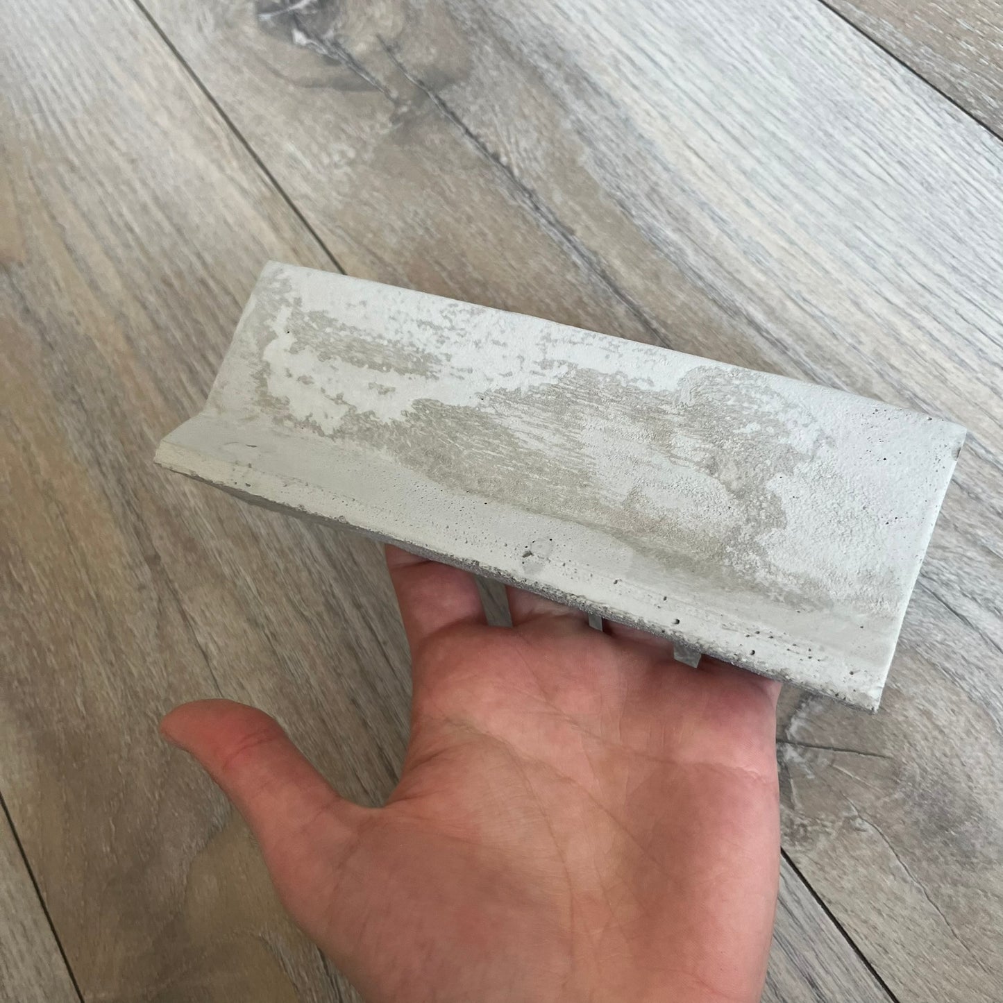 Supreme SS26 Mini Materials 1:12 Scale Jersey Barrier is a grey miniature accessory released on March 26, 2026, as part of the Spring/Summer 2026 collection. The piece replicates a standard jersey barrier in 1:12 scale with realistic construction-style detailing. This item was produced as part of Supreme’s Mini Materials accessory line.