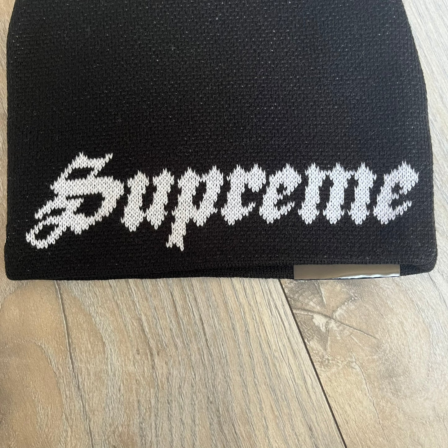 Supreme SS26 New Era Ghostface Black Beanie is a black knit beanie released on March 26, 2026, as part of the Spring/Summer 2026 collection. The front features a white Ghostface graphic, while the back includes “Supreme” text in a gothic-style font, with a small New Era logo embroidered on the side. The beanie is constructed from knit fabric for warmth and everyday wear.
