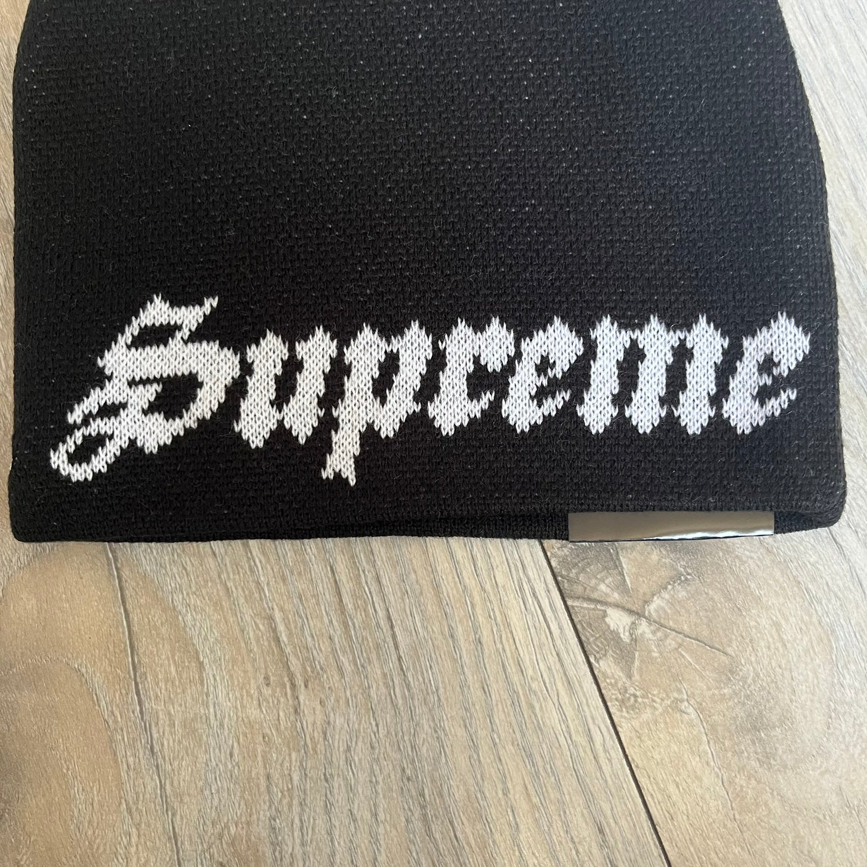 Supreme SS26 New Era Ghostface Black Beanie is a black knit beanie released on March 26, 2026, as part of the Spring/Summer 2026 collection. The front features a white Ghostface graphic, while the back includes “Supreme” text in a gothic-style font, with a small New Era logo embroidered on the side. The beanie is constructed from knit fabric for warmth and everyday wear.