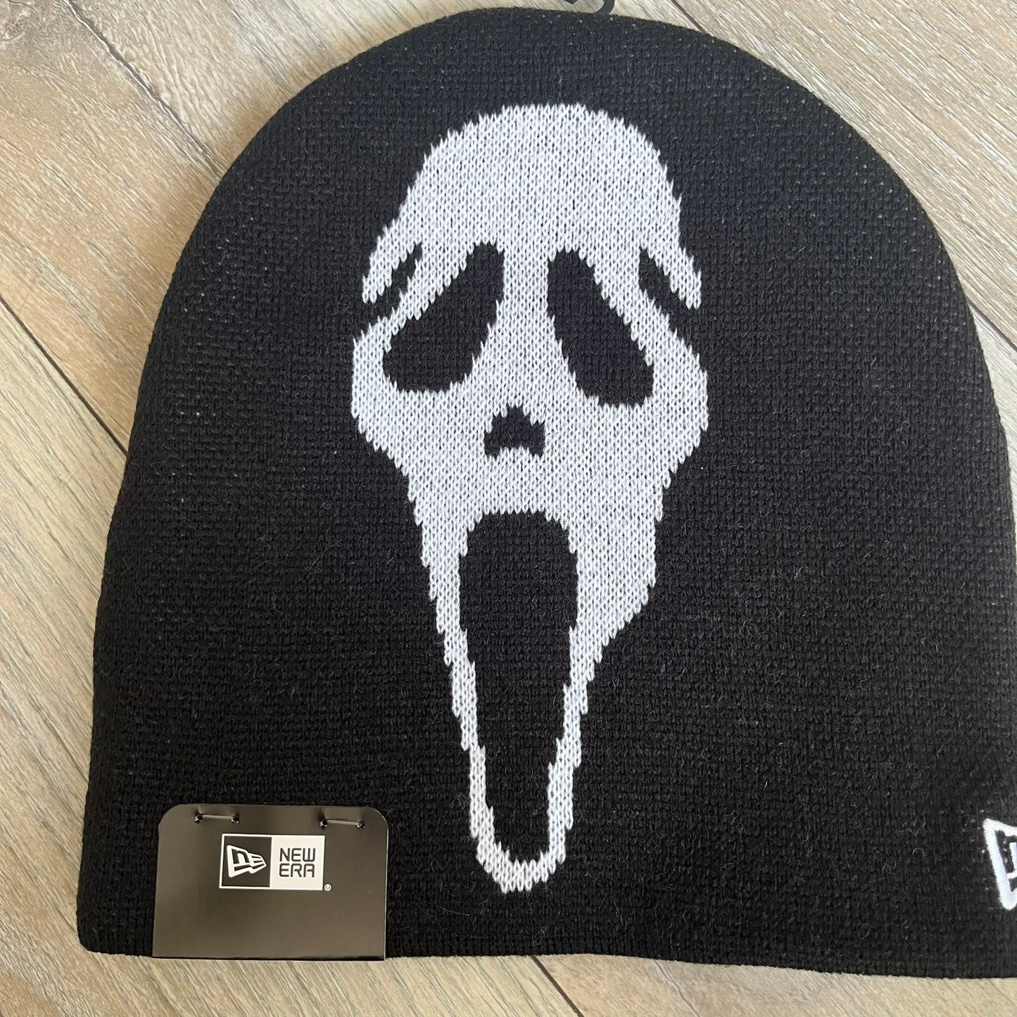 Supreme SS26 New Era Ghostface Black Beanie is a black knit beanie released on March 26, 2026, as part of the Spring/Summer 2026 collection. The front features a white Ghostface graphic, while the back includes “Supreme” text in a gothic-style font, with a small New Era logo embroidered on the side. The beanie is constructed from knit fabric for warmth and everyday wear.