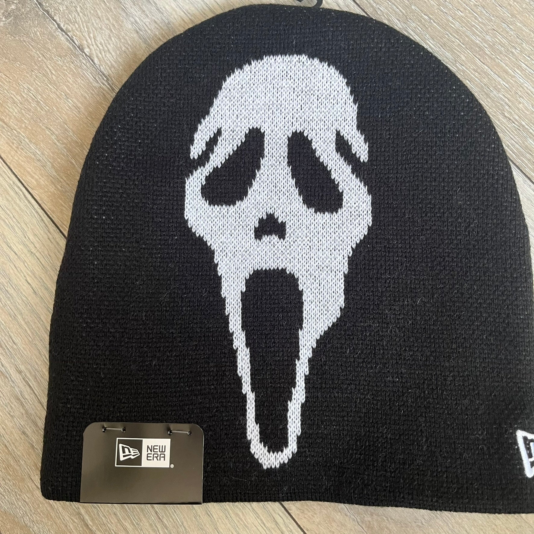 Supreme SS26 New Era Ghostface Black Beanie is a black knit beanie released on March 26, 2026, as part of the Spring/Summer 2026 collection. The front features a white Ghostface graphic, while the back includes “Supreme” text in a gothic-style font, with a small New Era logo embroidered on the side. The beanie is constructed from knit fabric for warmth and everyday wear.