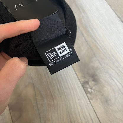 Supreme SS26 New Era Ghostface Black Beanie is a black knit beanie released on March 26, 2026, as part of the Spring/Summer 2026 collection. The front features a white Ghostface graphic, while the back includes “Supreme” text in a gothic-style font, with a small New Era logo embroidered on the side. The beanie is constructed from knit fabric for warmth and everyday wear.