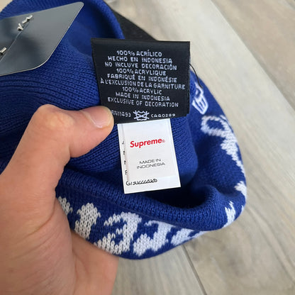 Supreme SS26 New Era Ghostface Black Beanie is a Royal (Blue) knit beanie released on March 26, 2026, as part of the Spring/Summer 2026 collection. The front features a white and black Ghostface graphic, while the back includes “Supreme” text in a gothic-style font, with a small New Era logo embroidered on the side. The beanie is constructed from knit fabric for warmth and everyday wear.