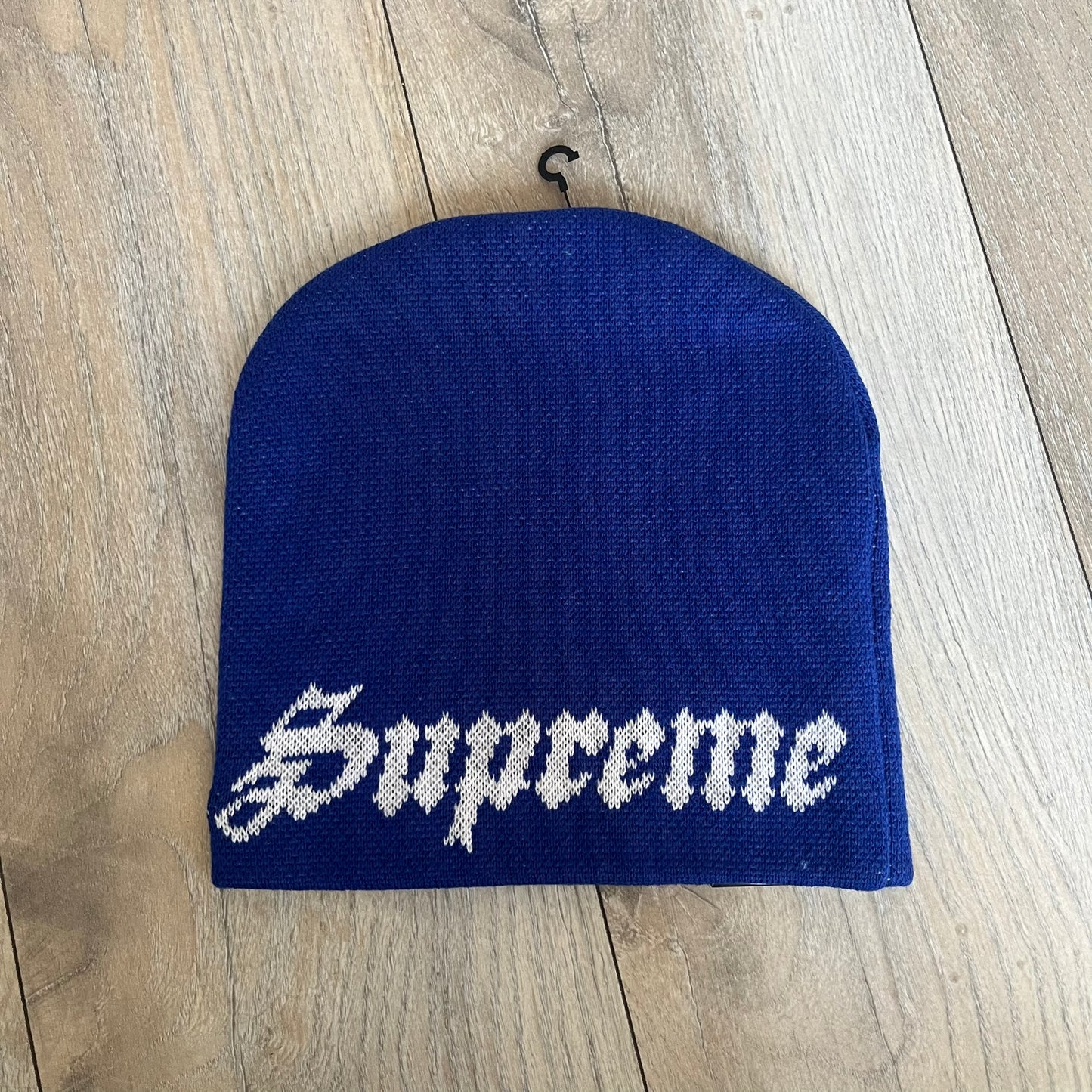 Supreme SS26 New Era Ghostface Black Beanie is a Royal (Blue) knit beanie released on March 26, 2026, as part of the Spring/Summer 2026 collection. The front features a white and black Ghostface graphic, while the back includes “Supreme” text in a gothic-style font, with a small New Era logo embroidered on the side. The beanie is constructed from knit fabric for warmth and everyday wear.