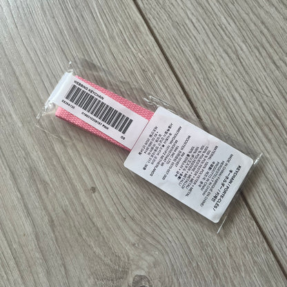  Supreme SS26 Webbing Keychain is a pink keychain from the Spring/Summer 2026 collection. It features a silver-tone 1-inch keyring and a pink rubber Supreme box logo patch attached to the front. The reverse side is plain with no additional graphics.