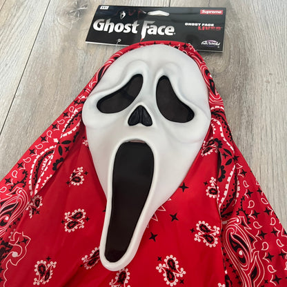 Supreme SS26 Ghostface Mask is a PVC face mask released on April 30, 2026, as part of the Spring/Summer 2026 collection. The mask features the classic white Ghostface design, combined with a red fabric hood element covered in white and black bandana-style patterns and integrated Supreme tags. Additional hanging strips on the sides enhance the hooded visual effect.