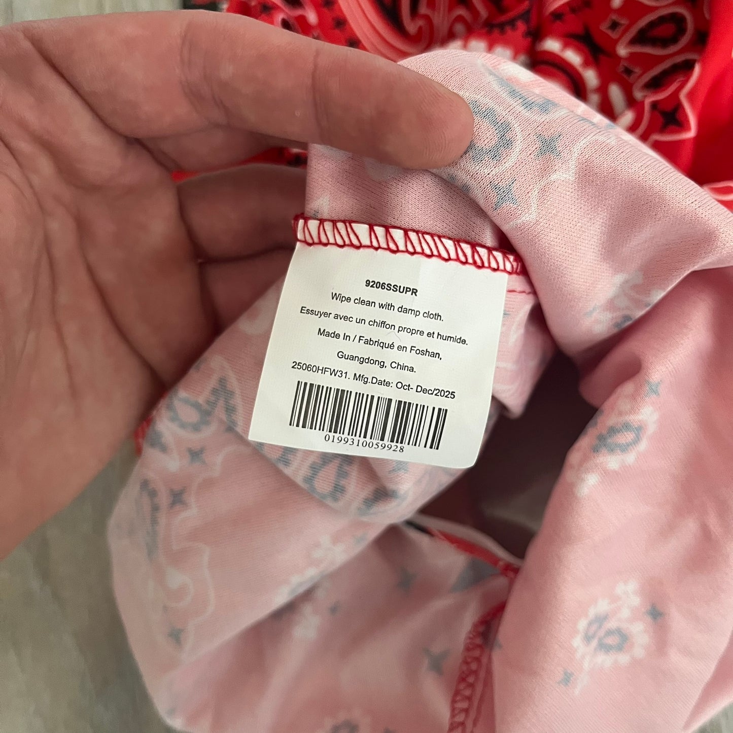 Supreme SS26 Ghostface Mask is a PVC face mask released on April 30, 2026, as part of the Spring/Summer 2026 collection. The mask features the classic white Ghostface design, combined with a red fabric hood element covered in white and black bandana-style patterns and integrated Supreme tags. Additional hanging strips on the sides enhance the hooded visual effect.