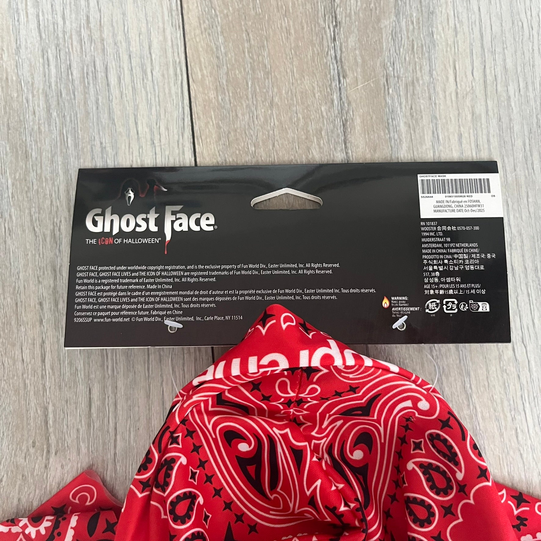 Supreme SS26 Ghostface Mask is a PVC face mask released on April 30, 2026, as part of the Spring/Summer 2026 collection. The mask features the classic white Ghostface design, combined with a red fabric hood element covered in white and black bandana-style patterns and integrated Supreme tags. Additional hanging strips on the sides enhance the hooded visual effect.