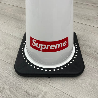 The Supreme Traffic Cone FW25 White features a clean white PVC body with a classic red Supreme box logo on the lower front. Designed for display purposes only, it sits on a black base and is not intended for use as a functional traffic marker. Released on October 16, 2025.