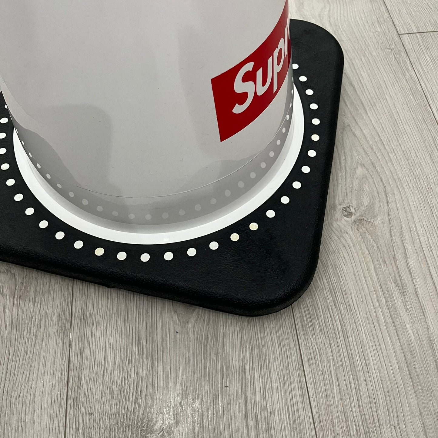 The Supreme Traffic Cone FW25 White features a clean white PVC body with a classic red Supreme box logo on the lower front. Designed for display purposes only, it sits on a black base and is not intended for use as a functional traffic marker. Released on October 16, 2025.