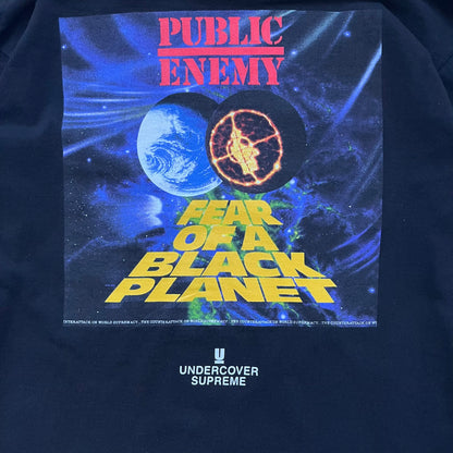 Supreme Undercover Public Enemy Counterattack SS18 Longsleeve Tee is a black long-sleeve T-shirt released on March 15, 2018, crafted from 100% cotton. The front features white “The Counterattack On World Supremacy” text with a small Supreme UNDERCOVER logo beneath, while the back displays a large Public Enemy “Fear of a Black Planet” graphic with galaxy and planet imagery and the same co-branded logo below. The design includes a ribbed crewneck and ribbed cuffs, reflecting the SS18 collaboration between Sup