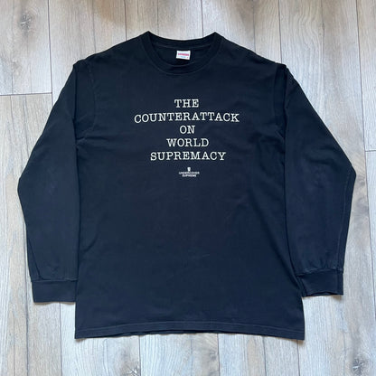Supreme Undercover Public Enemy Counterattack SS18 Longsleeve Tee is a black long-sleeve T-shirt released on March 15, 2018, crafted from 100% cotton. The front features white “The Counterattack On World Supremacy” text with a small Supreme UNDERCOVER logo beneath, while the back displays a large Public Enemy “Fear of a Black Planet” graphic with galaxy and planet imagery and the same co-branded logo below. The design includes a ribbed crewneck and ribbed cuffs, reflecting the SS18 collaboration between Sup