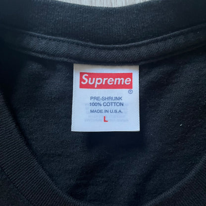 Supreme “Weather” FW23 tee in black, showcasing a satirical weather map graphic of the USA. Below sits a gradient bar in red-to-pink tones, with every category marked “Shitty.” Includes small Supreme New York text detail, true to the collection.