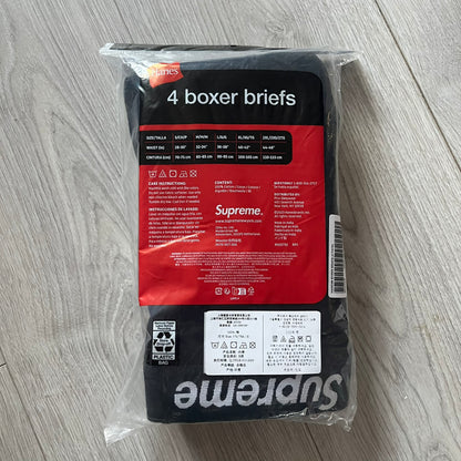 Supreme x Hanes black boxer briefs made of cotton with a stretch fit. Features a black elastic waistband with white Supreme logo text in Futura Oblique font. Classic Hanes base model with co-branded detailing.