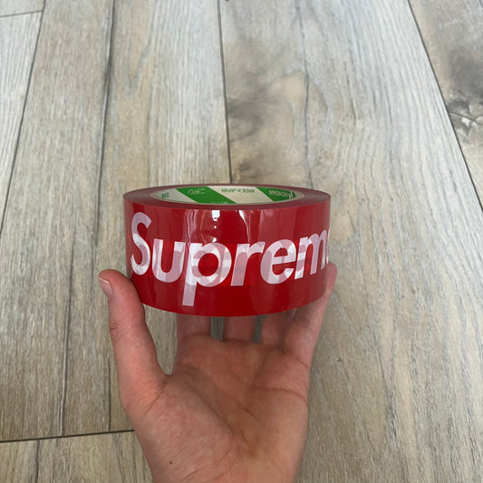 Supreme x Nichiban Packing Tape Red is a single roll of durable packing tape released as part of the Spring/Summer 2026 collection on May 21, 2026. Made in Japan exclusively for Supreme, the tape features an all-over red design with repeating white Supreme box logo prints. The roll is designed for practical use while also functioning as a collectible branded accessory.