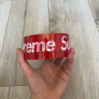 Supreme x Nichiban Packing Tape Red is a single roll of durable packing tape released as part of the Spring/Summer 2026 collection on May 21, 2026. Made in Japan exclusively for Supreme, the tape features an all-over red design with repeating white Supreme box logo prints. The roll is designed for practical use while also functioning as a collectible branded accessory.