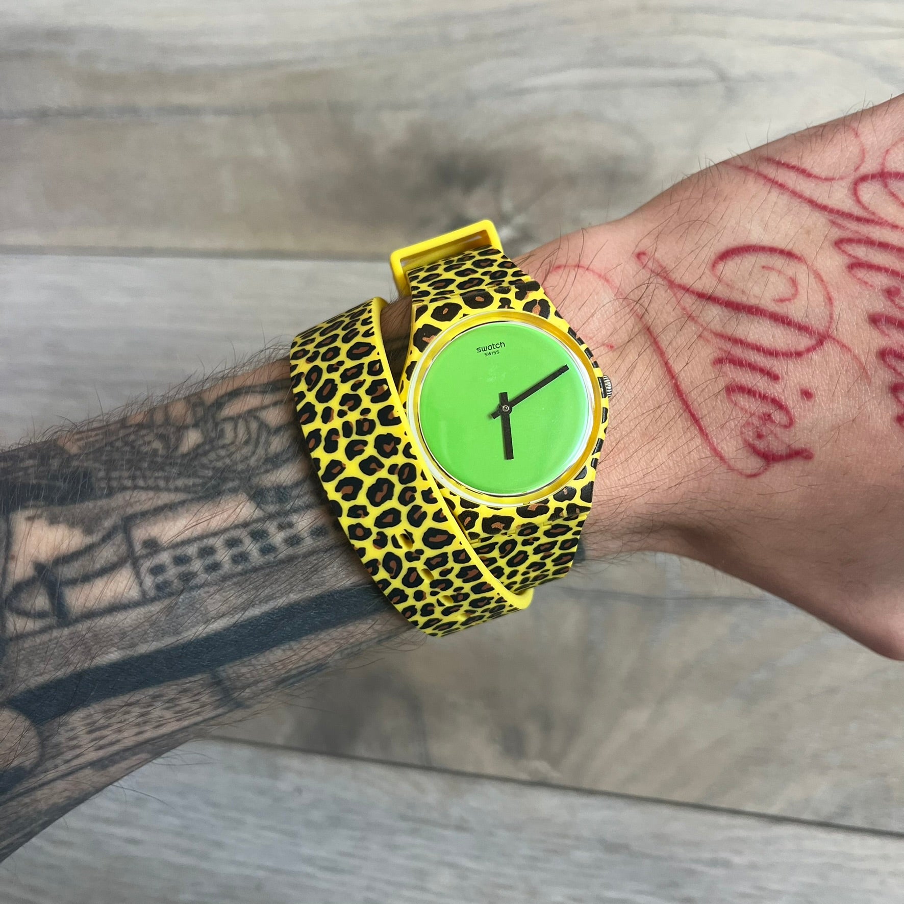 Swatch x Jeremy Scott 2011 Punk Analog Watch GZ251 is a quartz watch from the Gent Original line featuring a bright green dial with black hands and a plastic case. The design includes a comically long silicone strap with leopard print that wraps twice around the wrist, secured with multiple yellow loops, and Jeremy Scott branding on the upper strap. The watch is water resistant to 3 bar and comes with original box and papers
