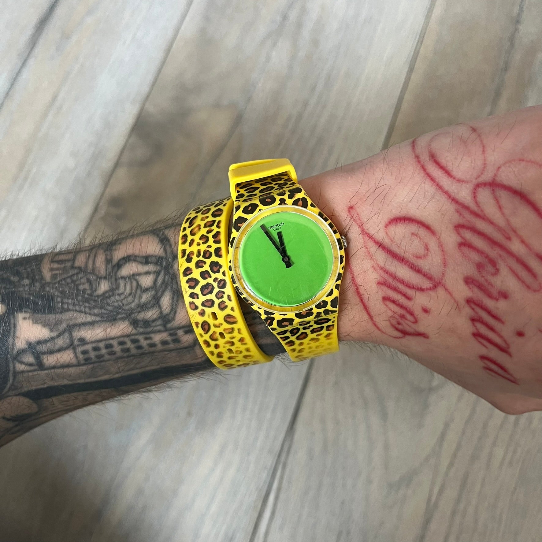 Swatch x Jeremy Scott 2011 Punk Analog Watch GZ251 is a quartz watch from the Gent Original line featuring a bright green dial with black hands and a plastic case. The design includes a comically long silicone strap with leopard print that wraps twice around the wrist, secured with multiple yellow loops, and Jeremy Scott branding on the upper strap. The watch is water resistant to 3 bar and comes with original box and papers.