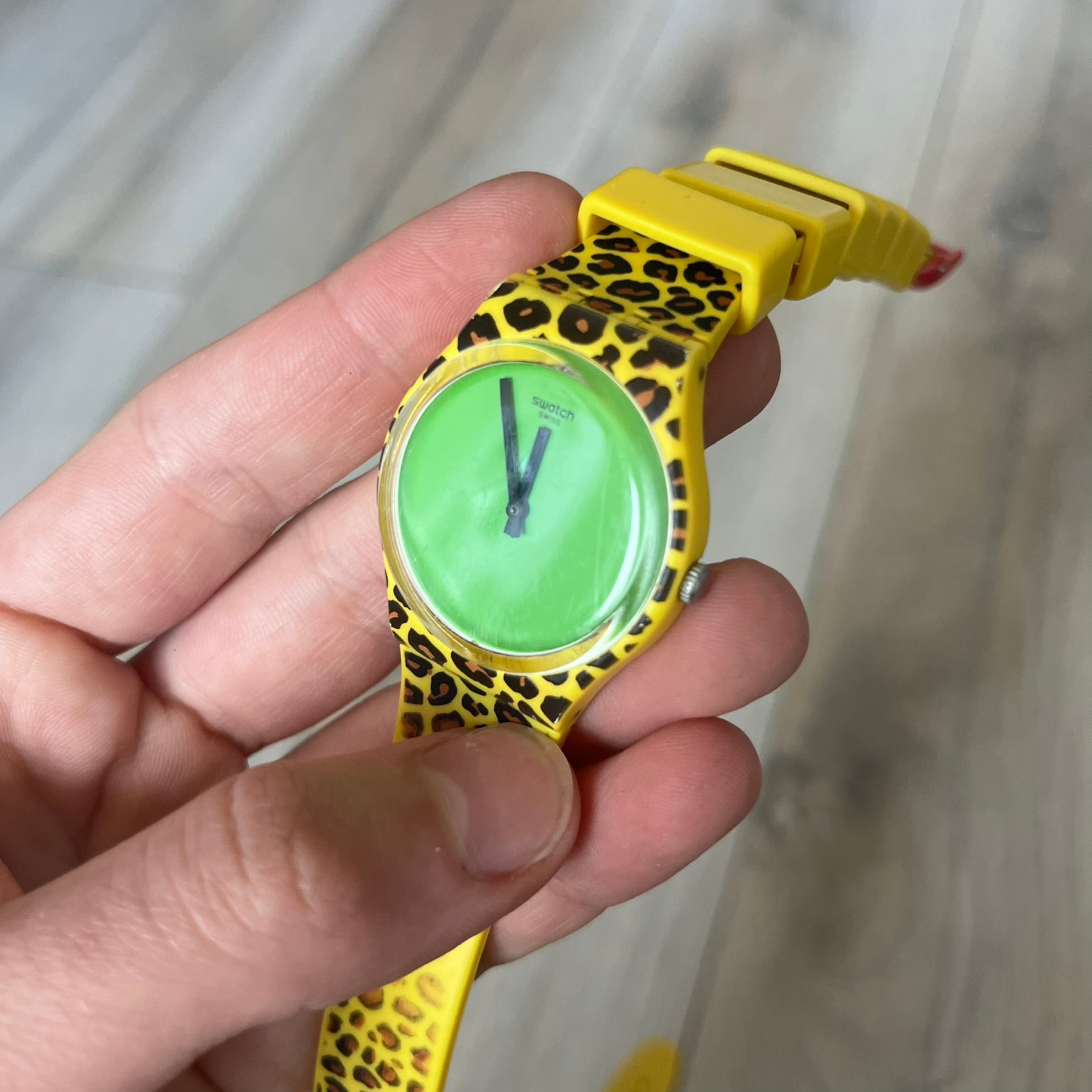 Swatch x Jeremy Scott 2011 Punk Analog Watch GZ251 is a quartz watch from the Gent Original line featuring a bright green dial with black hands and a plastic case. The design includes a comically long silicone strap with leopard print that wraps twice around the wrist, secured with multiple yellow loops, and Jeremy Scott branding on the upper strap. The watch is water resistant to 3 bar and comes with original box and papers.