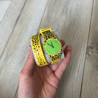 Swatch x Jeremy Scott 2011 Punk Analog Watch GZ251 is a quartz watch from the Gent Original line featuring a bright green dial with black hands and a plastic case. The design includes a comically long silicone strap with leopard print that wraps twice around the wrist, secured with multiple yellow loops, and Jeremy Scott branding on the upper strap. The watch is water resistant to 3 bar and comes with original box and papers.