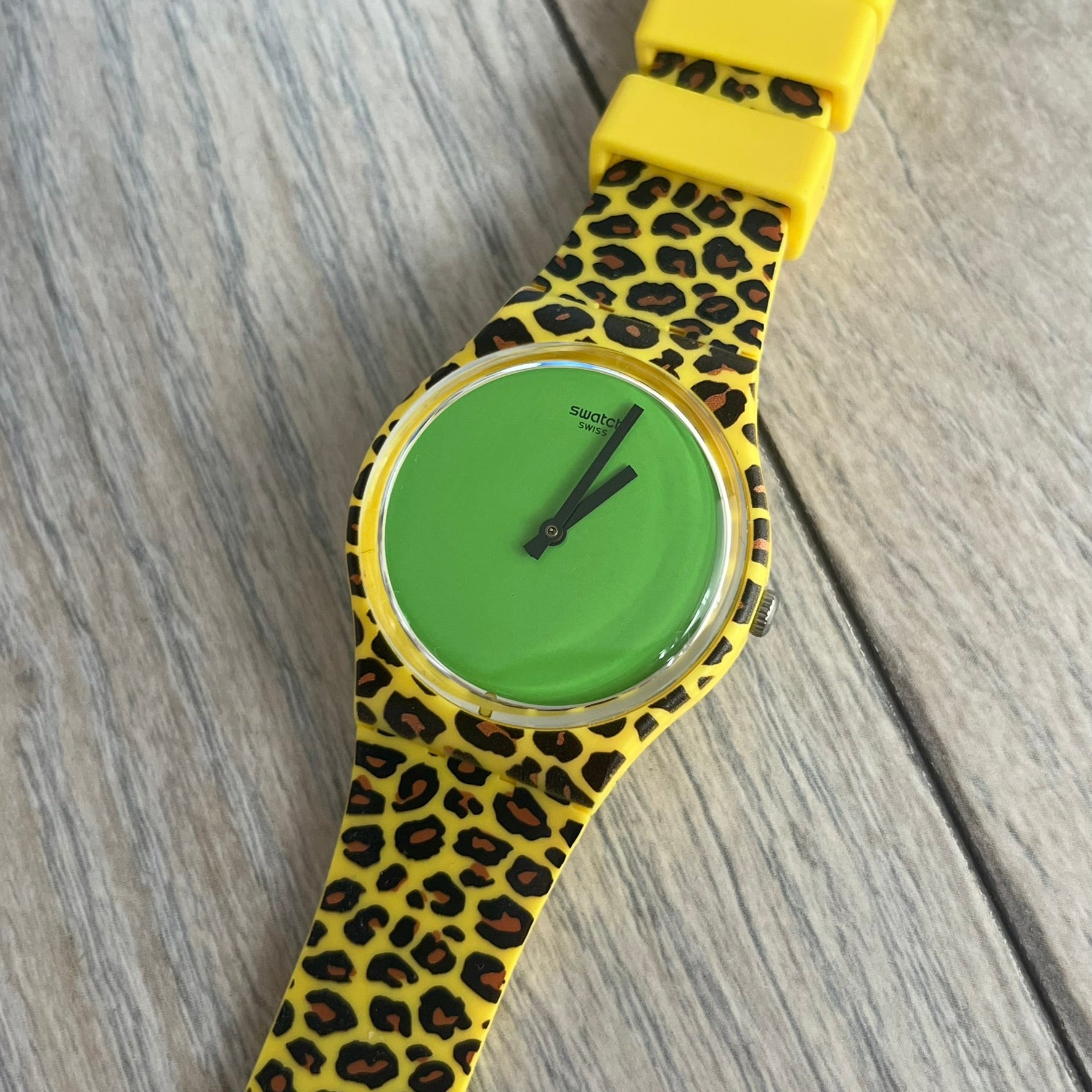 Swatch x Jeremy Scott 2011 Punk Analog Watch GZ251 is a quartz watch from the Gent Original line featuring a bright green dial with black hands and a plastic case. The design includes a comically long silicone strap with leopard print that wraps twice around the wrist, secured with multiple yellow loops, and Jeremy Scott branding on the upper strap. The watch is water resistant to 3 bar and comes with original box and papers