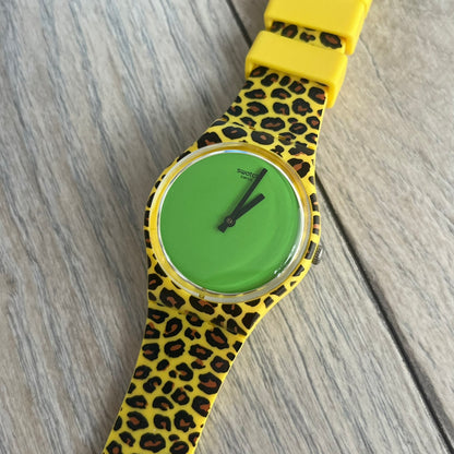 Swatch x Jeremy Scott 2011 Punk Analog Watch GZ251 is a quartz watch from the Gent Original line featuring a bright green dial with black hands and a plastic case. The design includes a comically long silicone strap with leopard print that wraps twice around the wrist, secured with multiple yellow loops, and Jeremy Scott branding on the upper strap. The watch is water resistant to 3 bar and comes with original box and papers