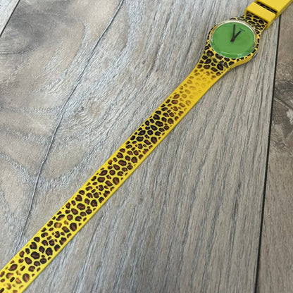 Swatch x Jeremy Scott 2011 Punk Analog Watch GZ251 is a quartz watch from the Gent Original line featuring a bright green dial with black hands and a plastic case. The design includes a comically long silicone strap with leopard print that wraps twice around the wrist, secured with multiple yellow loops, and Jeremy Scott branding on the upper strap. The watch is water resistant to 3 bar and comes with original box and papers.