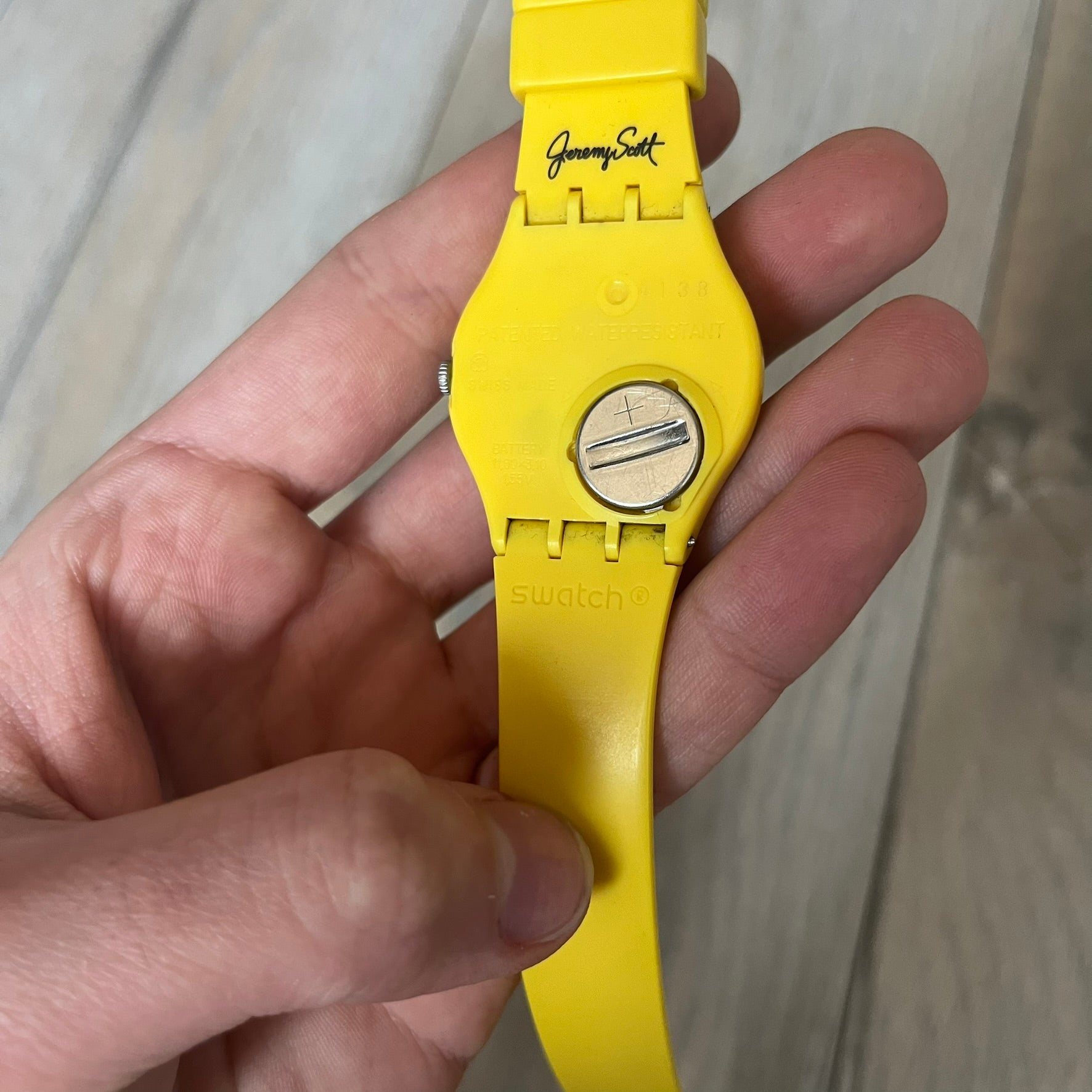 Swatch x Jeremy Scott 2011 Punk Analog Watch GZ251 is a quartz watch from the Gent Original line featuring a bright green dial with black hands and a plastic case. The design includes a comically long silicone strap with leopard print that wraps twice around the wrist, secured with multiple yellow loops, and Jeremy Scott branding on the upper strap. The watch is water resistant to 3 bar and comes with original box and papers.