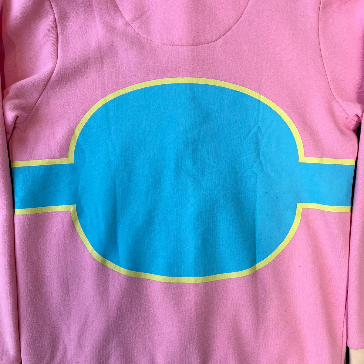 Team Fortress 2 Balloonicorn 2015 WeLoveFine Zip-Up Hoodie is a bright pink unisex colorblock hoodie from Valve’s Team Fortress 2 line, with a detailed 3D plush Balloonicorn hood featuring embroidered eyes, a 3D horn, nose, and ears. It has front pockets, a custom metal Balloonicorn cameo zipper pull, and a light blue printed saddle graphic that wraps from the back to the front. The licensed TF2 neck tag carries 2015 and We Love Fine branding. Super rare.