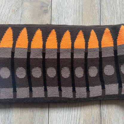 Officially licensed Team Fortress 2 merchandise released in 2014 by The Coop. This scarf is made from soft knit material and features a trompe-l’œil bullet bandolier graphic designed to replicate the ammunition belt worn by the Heavy character. Long and warm in construction, it displays repeated cartridge details along the length of the scarf.